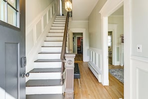 A staircase with a handrail, a bench, and a radiator on the floor.