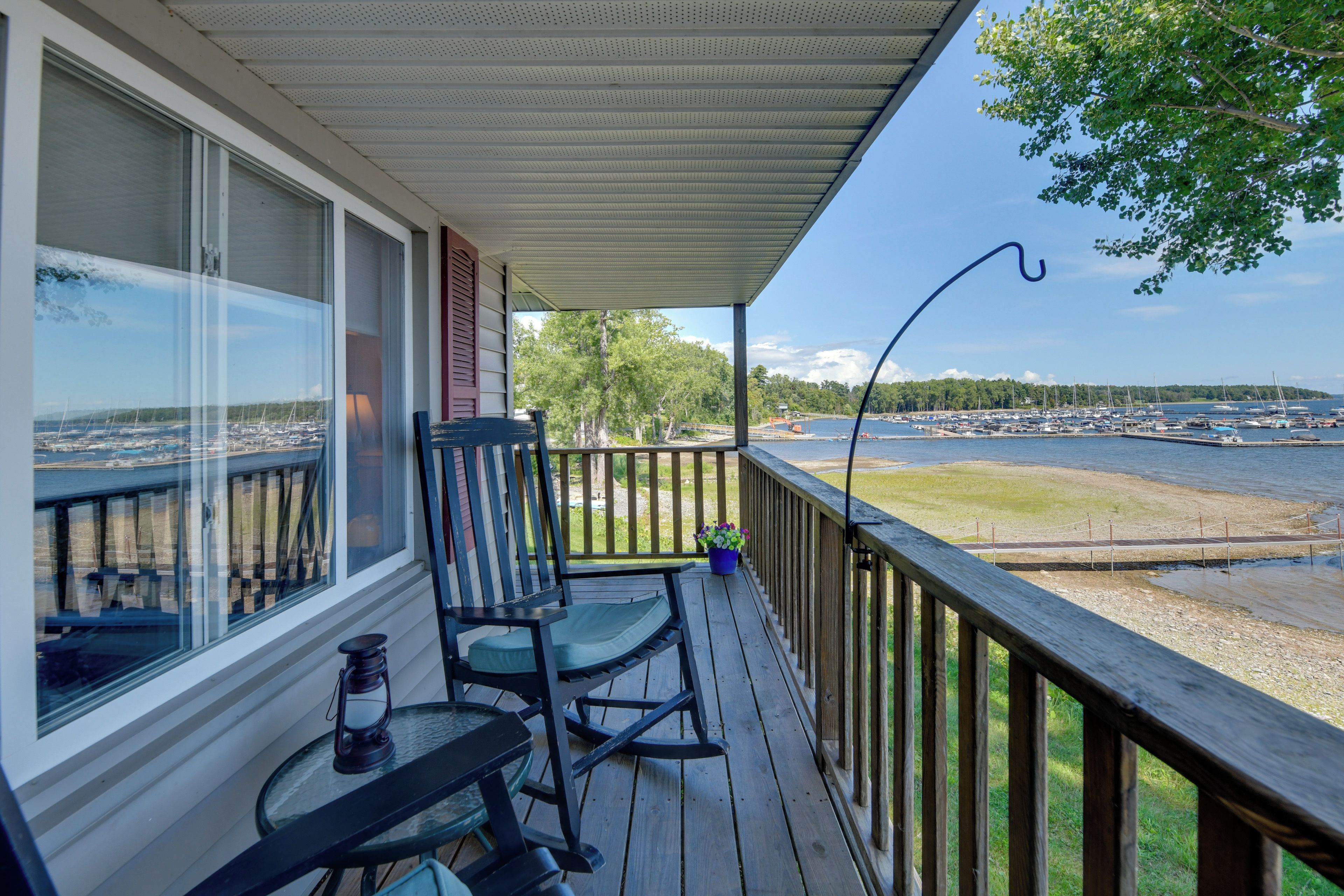 A wooden deck with a view of a marina and a body of water.