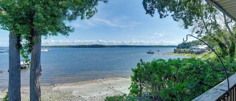 A lakeside view with boats, a dock, and a cabin.