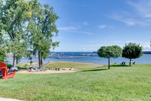 A grassy area with a view of a marina and boats. - Fire Pit & Views! Lake Champlain Shoreline Stay (Plattsburgh)