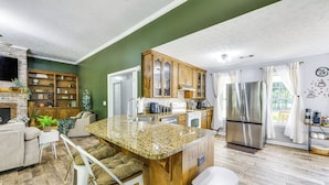 A modern kitchen with granite countertops, stainless steel appliances, and a wooden island. - Game Day Hideaway! Spacious Opelika Escape (Opelika)