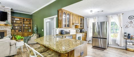 Una cocina moderna con encimeras de granito, electrodomésticos de acero inoxidable y una isla de madera.