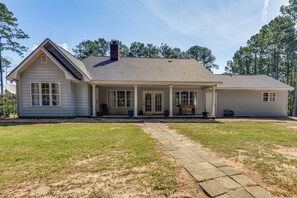 A single-story house with a front porch, a chimney, and a driveway leading to the entrance.