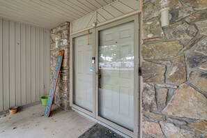A stone exterior wall, a door with a glass panel, and a welcome sign. - Sun Porch w/ Fireplace! Family Home By Little Rock (Alexander)