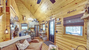 Un interno in legno con un angolo soggiorno accogliente, cucina e zona pranzo.