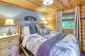 A cozy bedroom with a bed, two bedside tables, a wall clock, and a sign that reads 'The Best Place To Be Is Together.' - 'wolf Ridge Lodge' w/ Hot Tub & Fire Pit! (Mena)