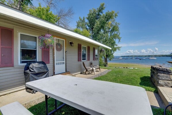A mobile home with a patio, outdoor seating, and a view of a lake with boats. - Lakefront Property With Beautiful Sunrises (Plattsburgh)