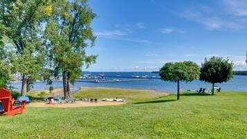 A grassy area with a clear view of a marina and boats.
