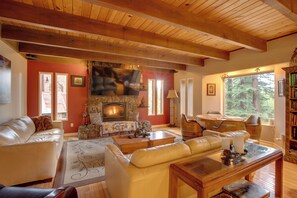 A cozy living room with a fireplace, leather sofas, a coffee table, and a bookshelf. - Near Heavenly & Lake Tahoe! Mountain Home, Hot Tub (South Lake Tahoe)