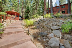 A stone staircase leading to a wooden gazebo in a forested area with a building in the background. - Near Heavenly & Lake Tahoe! Mountain Home, Hot Tub (South Lake Tahoe)