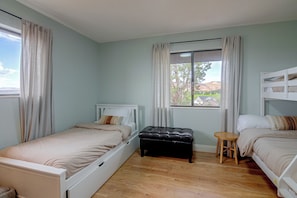 A bedroom with two single beds, a bench, a small stool, and a window with curtains. - Red Rock Retreat in Kanab Epic Views Near Zion (Kanab)