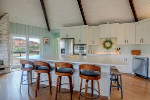 A spacious kitchen with a large island, bar stools, and a view of a mountainous landscape. - Red Rock Retreat in Kanab Epic Views Near Zion (Kanab)
