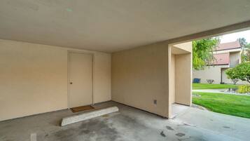 A room with a door, a small step leading to the entrance, and a concrete floor.