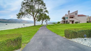 A pathway leading to a building with a view of a lake and mountains.