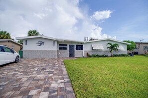 A modern two-story house with a paved driveway and a well-maintained lawn.