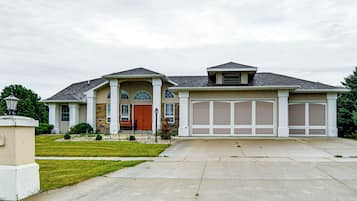 A two-story house with a front porch, a garage, and a well-maintained lawn.
