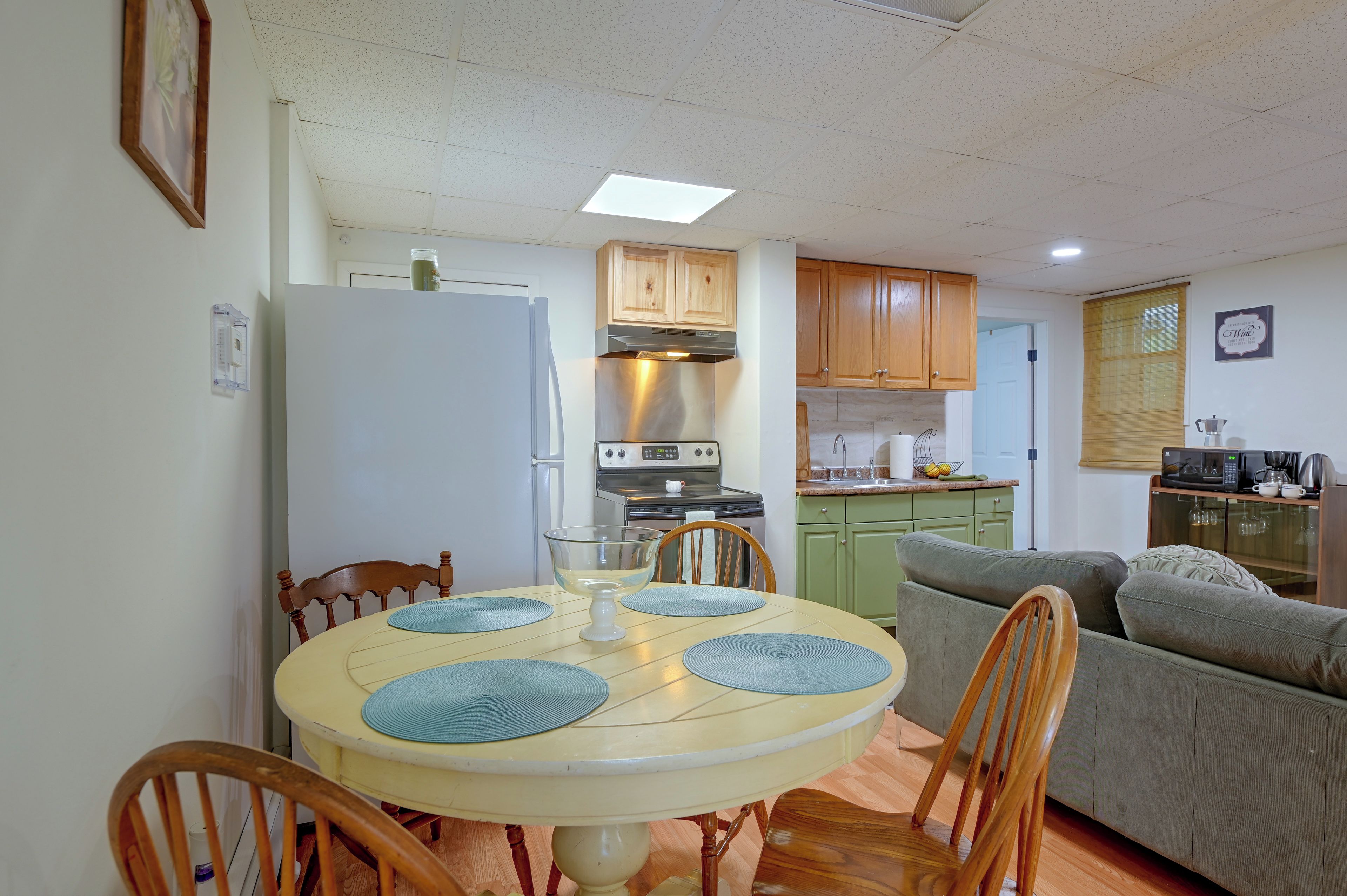 A compact kitchen with a dining area, wooden cabinets, and a microwave.