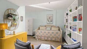 A bedroom with a bed, bedside tables, a wardrobe, a bookshelf, and a desk.