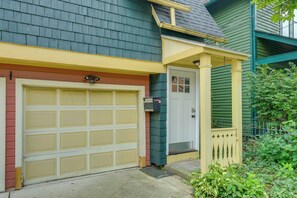 A residential garage with a yellow door and a small porch with a yellow railing.