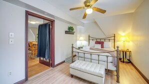 A bedroom with a bed, bedside lamps, a ceiling fan, and a small table with books. - 6 Mi to Dtwn! Historic Haven in Cleveland (Cleveland)