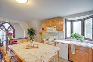 A kitchen with wooden cabinets, a white stove, and a window with a view. - 6 Mi to Dtwn! Historic Haven in Cleveland (Cleveland)