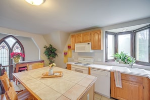 A kitchen with wooden cabinets, a white stove, and a window with a view. - 6 Mi to Dtwn! Historic Haven in Cleveland (Cleveland)