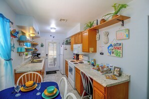 A compact kitchen with wooden cabinets, a microwave, and a sink. - Little Minnow - Just Minutes From the Water (Aransas Pass)