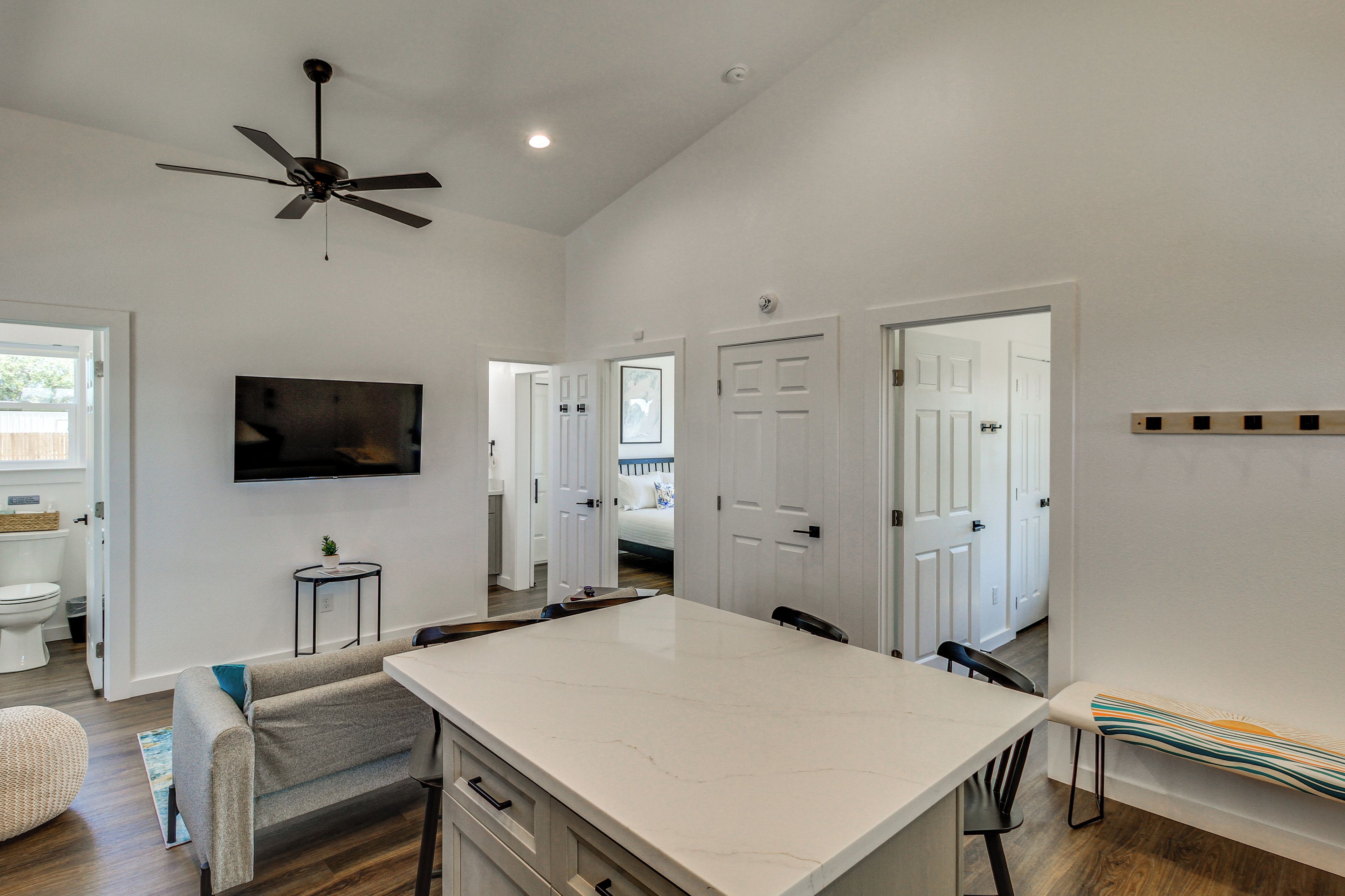 Een ruime keuken met een groot eiland, een plafondventilator en een flatscreen televisie aan de muur.