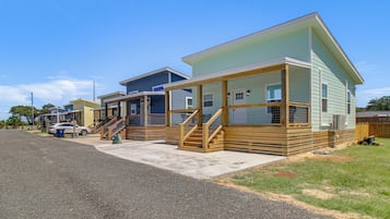 A row of mobile homes with wooden decks and steps leading to the entrance.