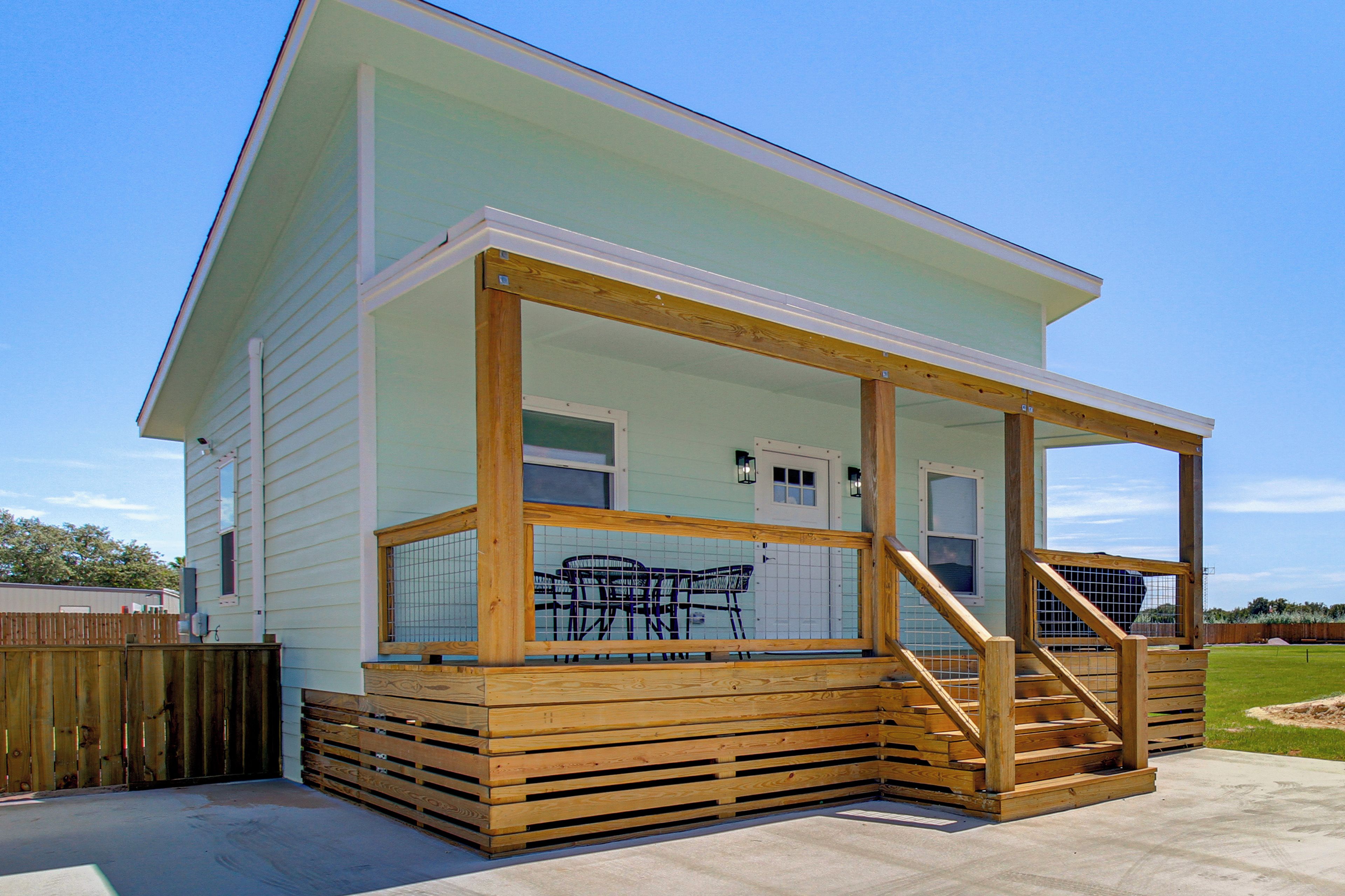 A two-story house with a covered porch and a wooden deck.