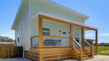 A two-story house with a covered porch and a wooden deck.