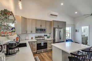 Una cocina moderna con electrodomésticos de acero inoxidable, armarios de madera y una isla central.