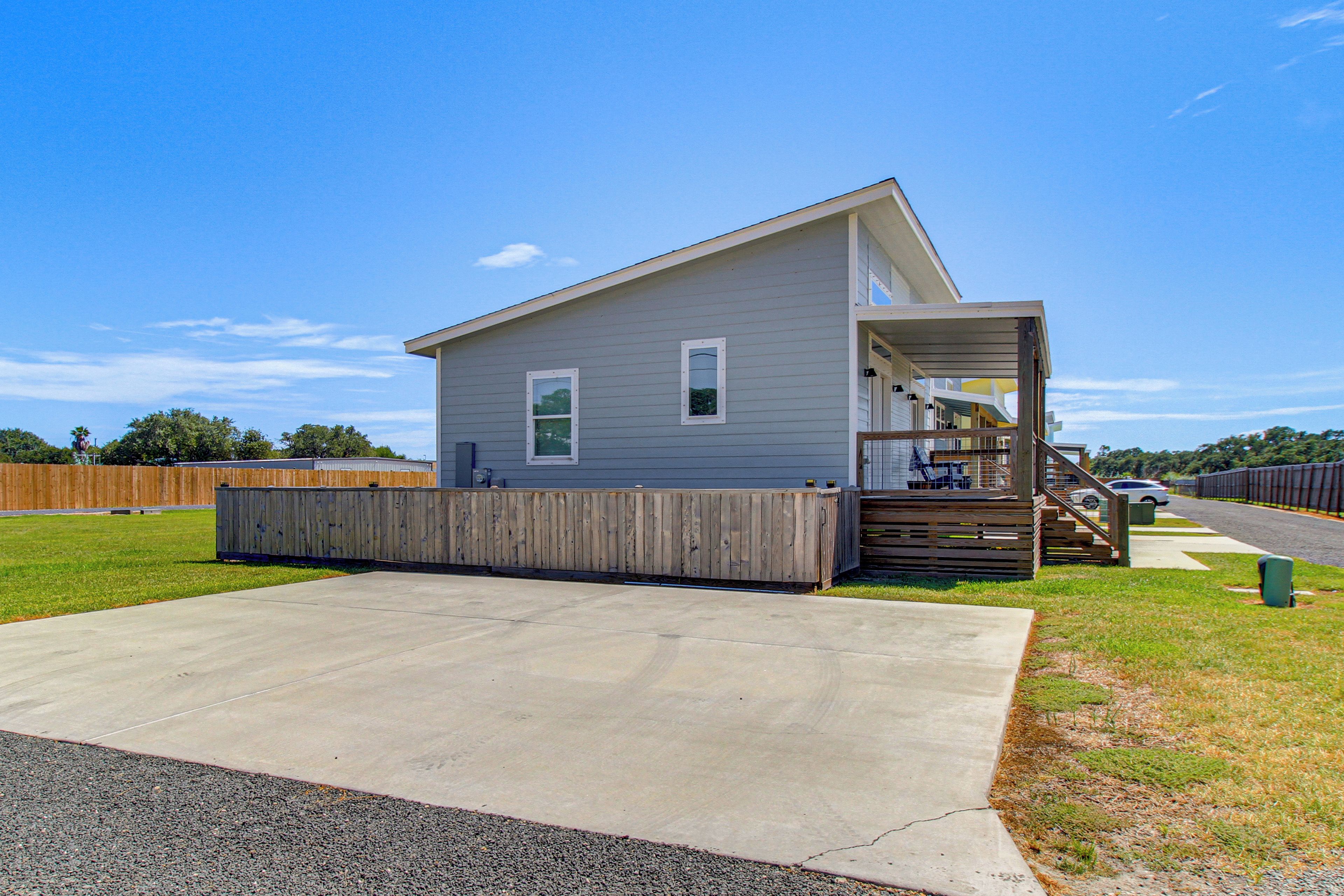 A single-story house with a front porch, a small deck, and a concrete driveway.
