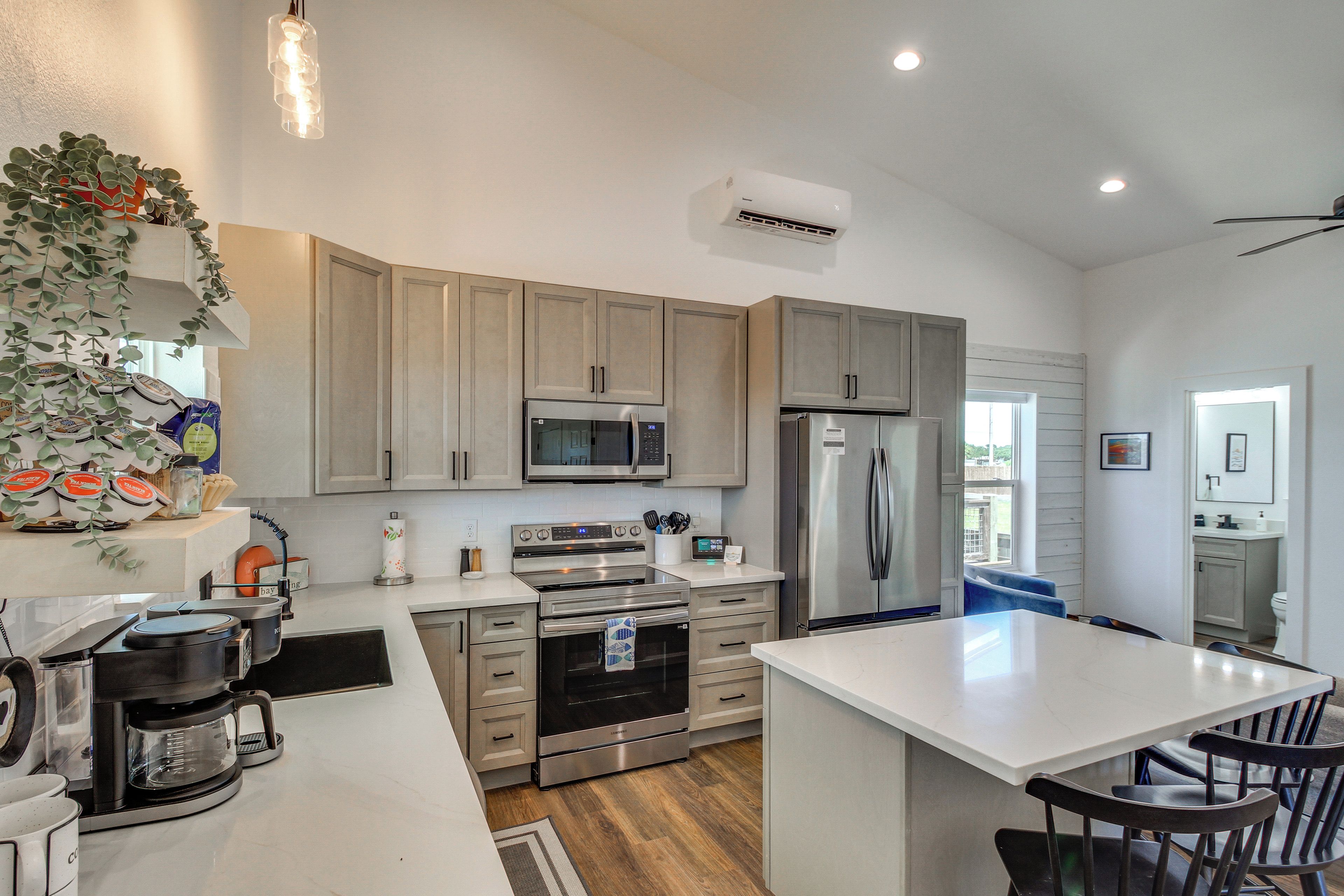 Una cocina moderna con electrodomésticos de acero inoxidable, armarios de madera y una isla central.