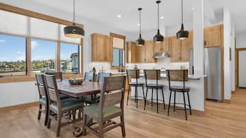 A modern kitchen with wooden cabinets, a central island, and pendant lighting.