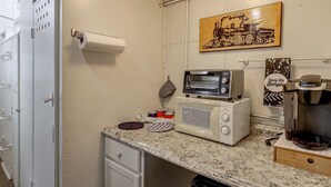 Una cuineta compacta amb microones, torradora i cafetera.