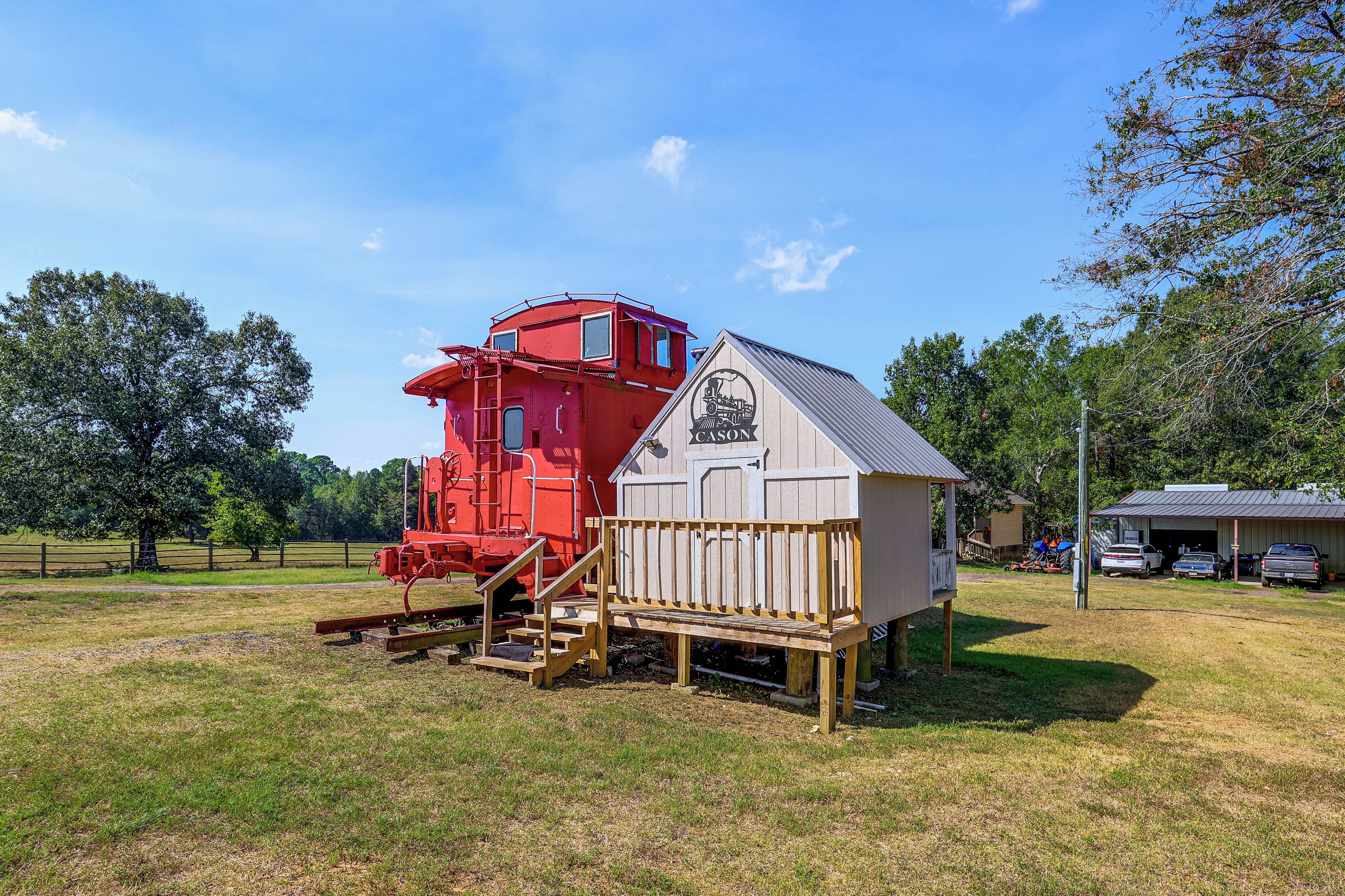 A red train engine and a white building with a ramp and stairs.