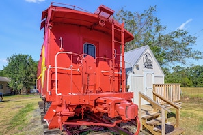 A red train caboose with a small wooden structure beside it. - Converted Caboose on 50 Acres! Unique Naples Gem (Omaha)