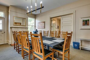 Comedor con una mesa dispuesta para seis personas, rodeada de sillas de madera con asientos acolchados.