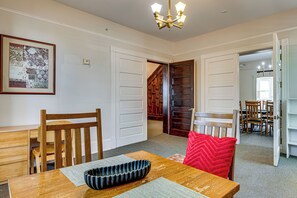 A dining area with a wooden table, chairs, and a red throw pillow. - 'agnes Arbor' Walkable Group Getaway in Decatur! (Decatur)