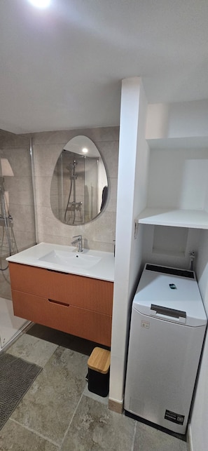 A bathroom with a white sink, mirror, and a small refrigerator. - Vrbo Property (La Ciotat)