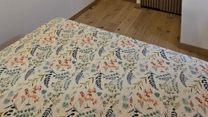 Un dormitorio con una cama, una puerta de madera y un aire acondicionado instalado en la pared.