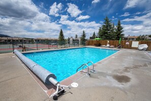 Una piscina amb una escala metàl·lica i una coberta.