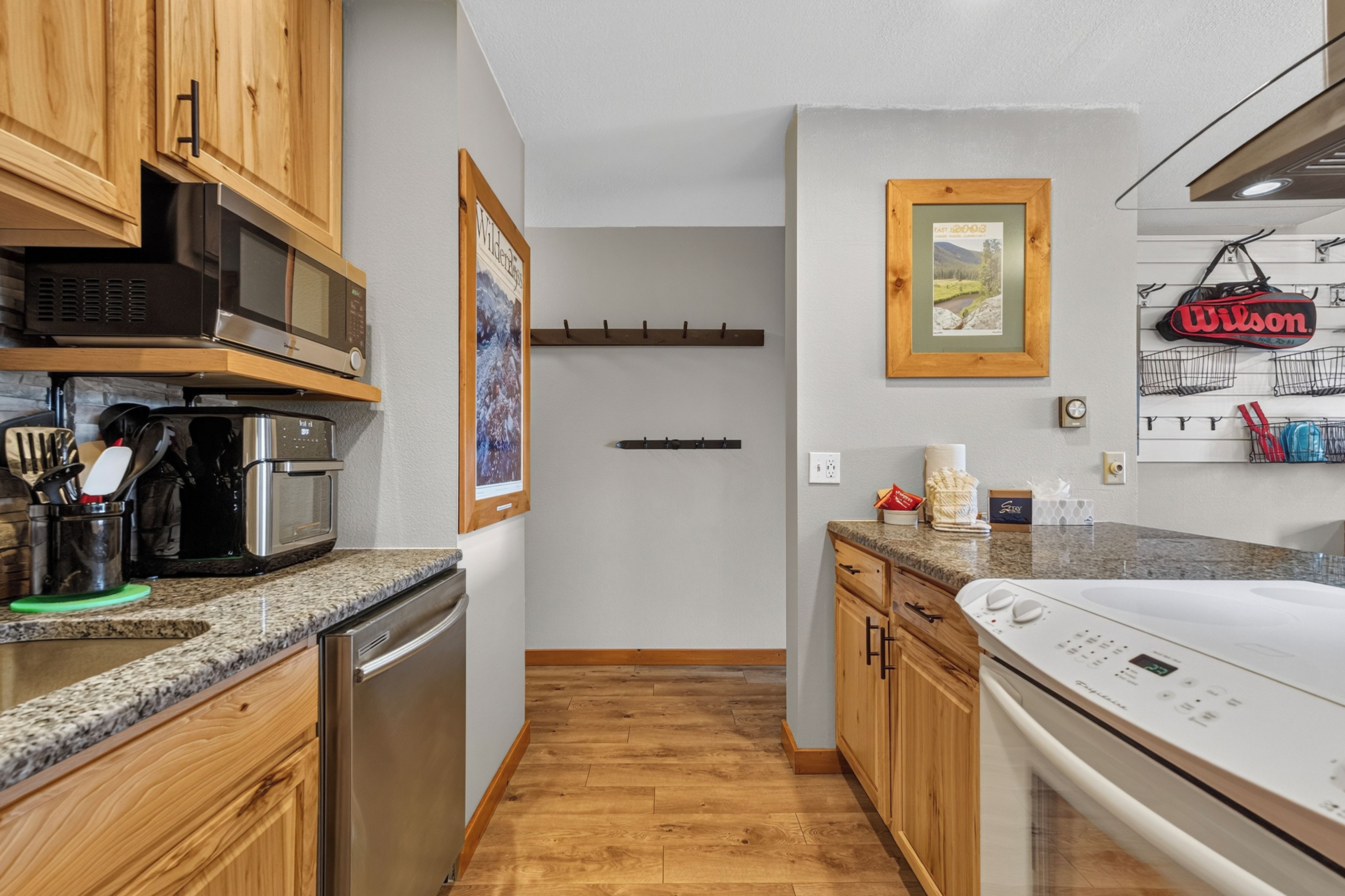 A modern kitchen with wooden cabinets, stainless steel appliances, and a granite countertop.