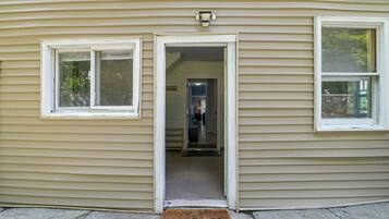 A house with a front door open, revealing an interior with a hallway and a door to a room.