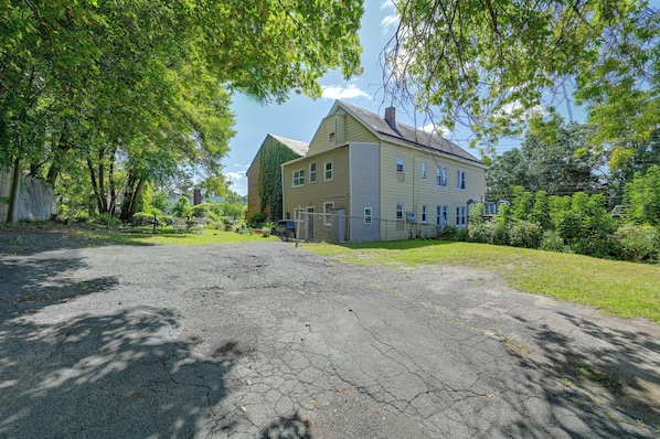 A two-story house with a large front yard and a paved driveway.