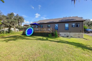 A residential house with a deck, a trampoline, and a clear sky. - Waterfront Interlachen Retreat w/ Dock on Lake Ida (Interlachen)