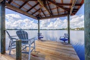 A wooden deck with two Adirondack chairs facing a calm lake. - Waterfront Interlachen Retreat w/ Dock on Lake Ida (Interlachen)