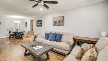 A living room with a sofa, coffee table, and a ceiling fan.