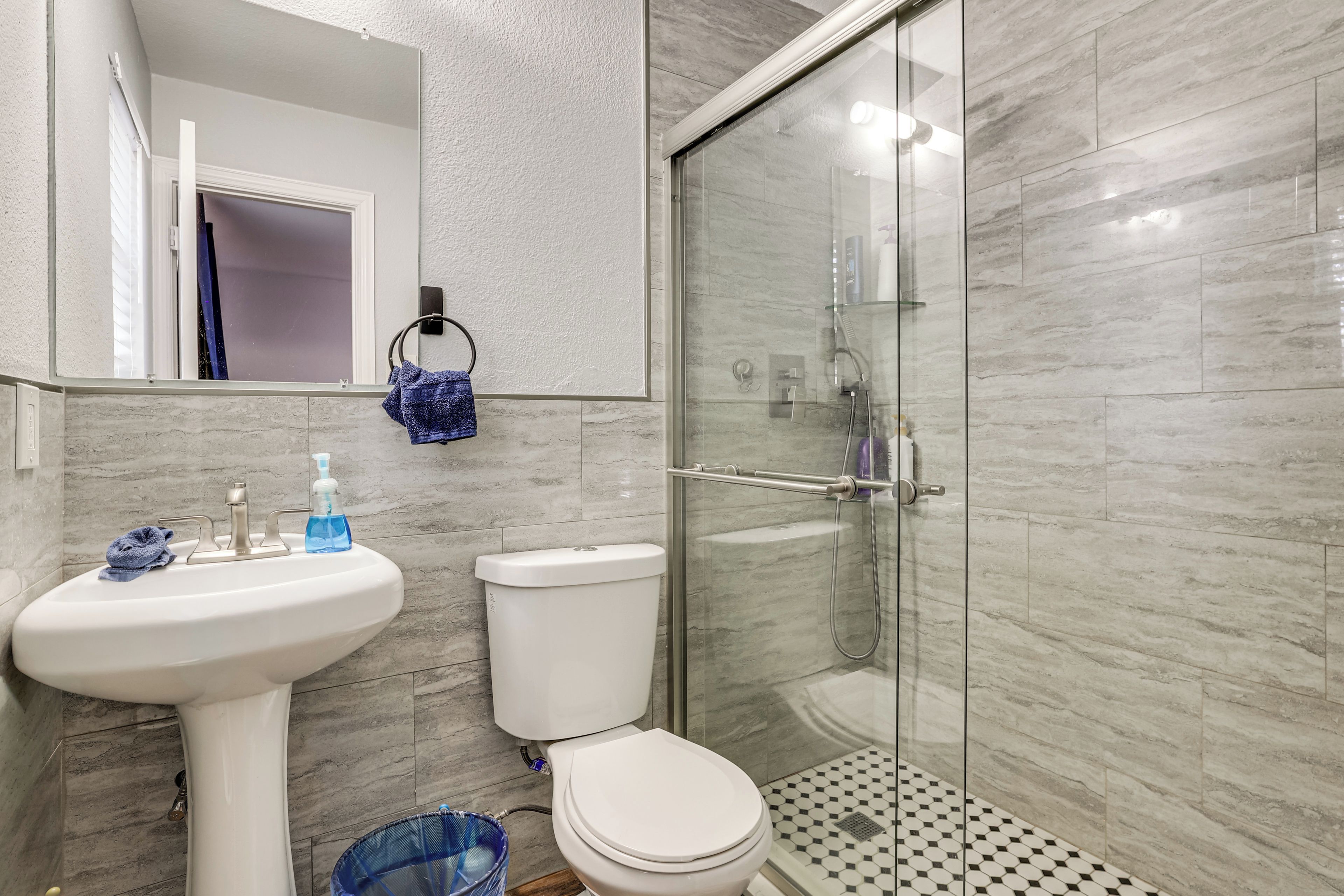 A bathroom with a sink, toilet, and glass shower enclosure.